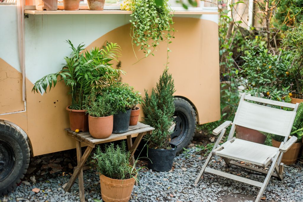 Kleine patio met potplanten en een comfortabele tuinstoel