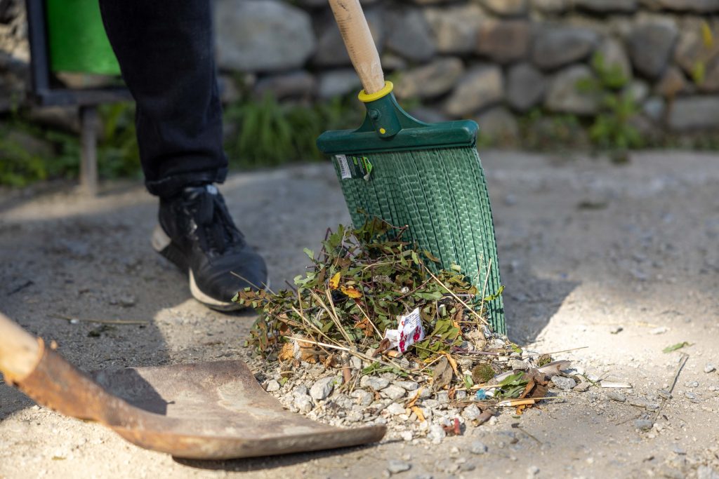Bladeren harken in de tuin in het najaar