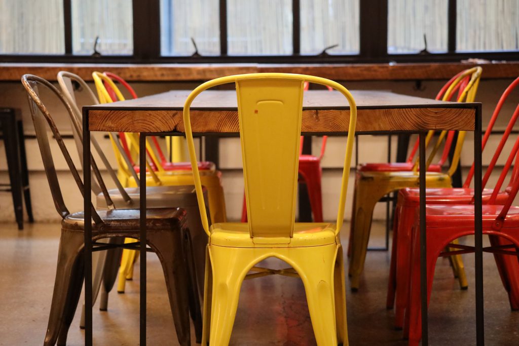 Gekleurde stoelen gecombineerd rond een houten eettafel