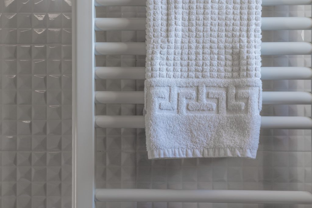 Witte handdoek op een radiator in een moderne betegelde badkamer