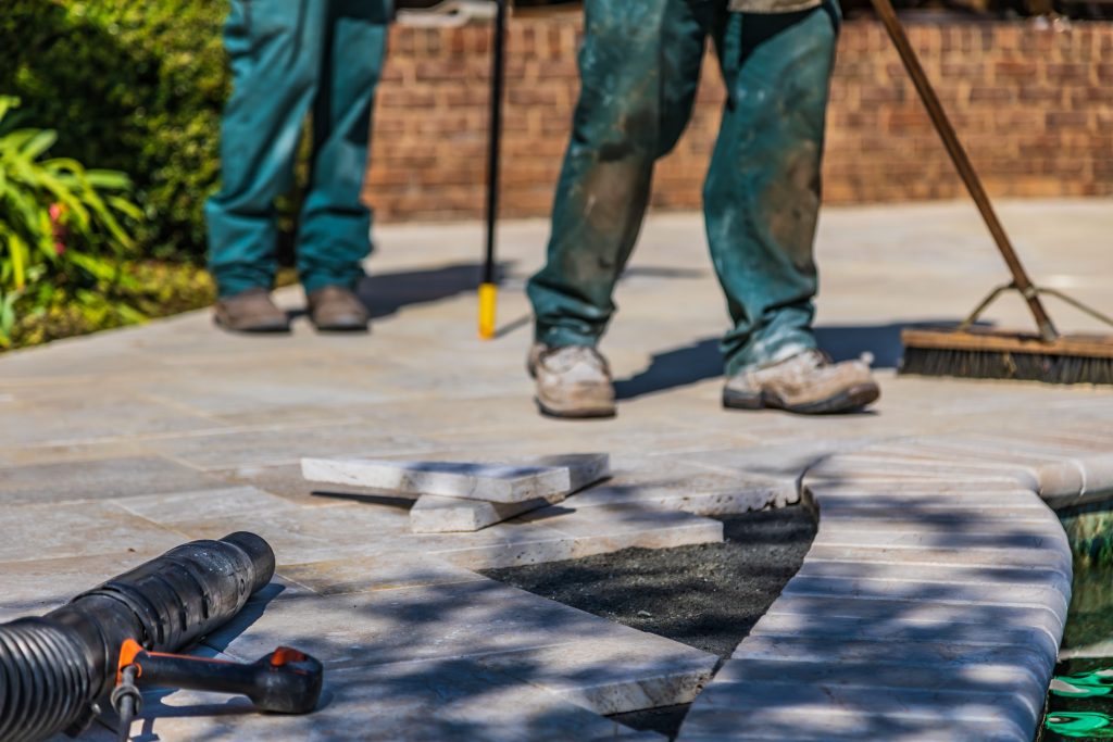 Tuintegels worden gelegd op een terras in de zon